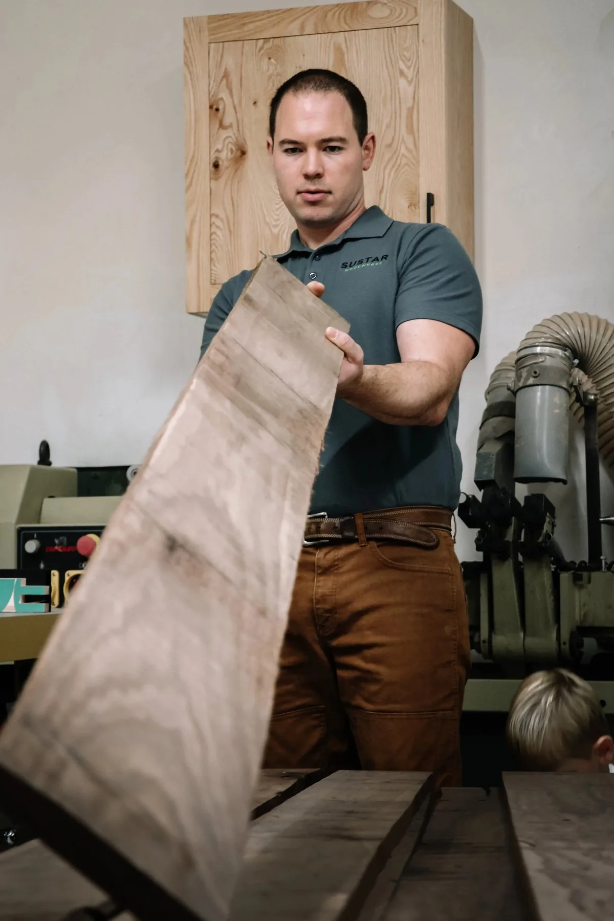 Ian Sustar sighting down a rough board in his workshop.